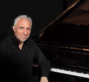 Jacques Loussier seated at a piano