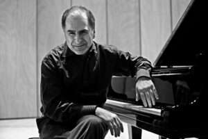 Enrico Pieranunzi seated by a piano