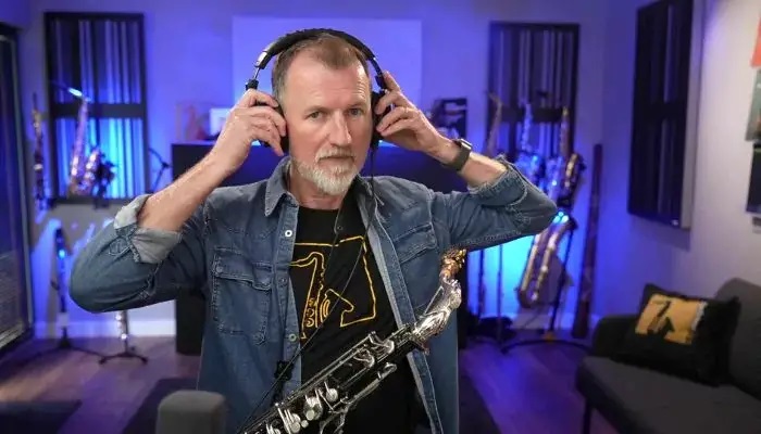 Saxophonist practicing with headphones