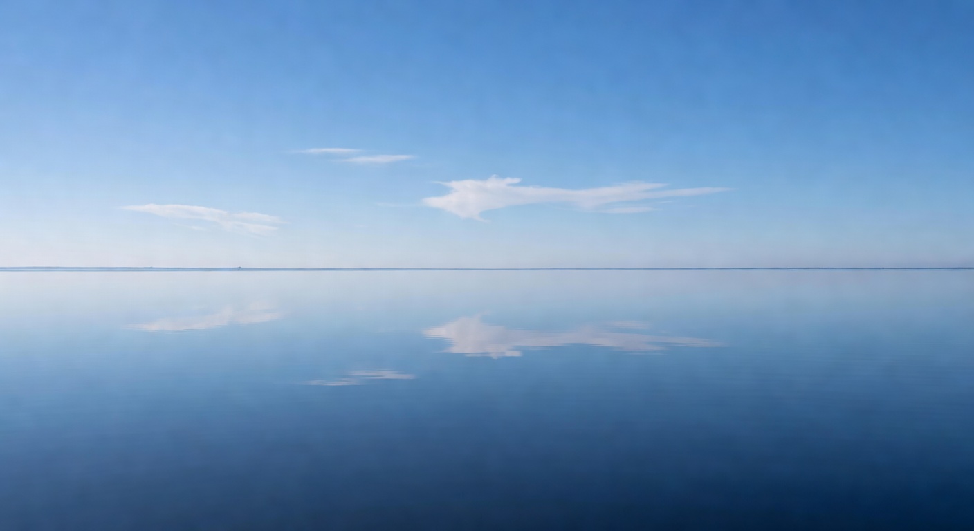 A calm still lake reflecting a clear blue sky