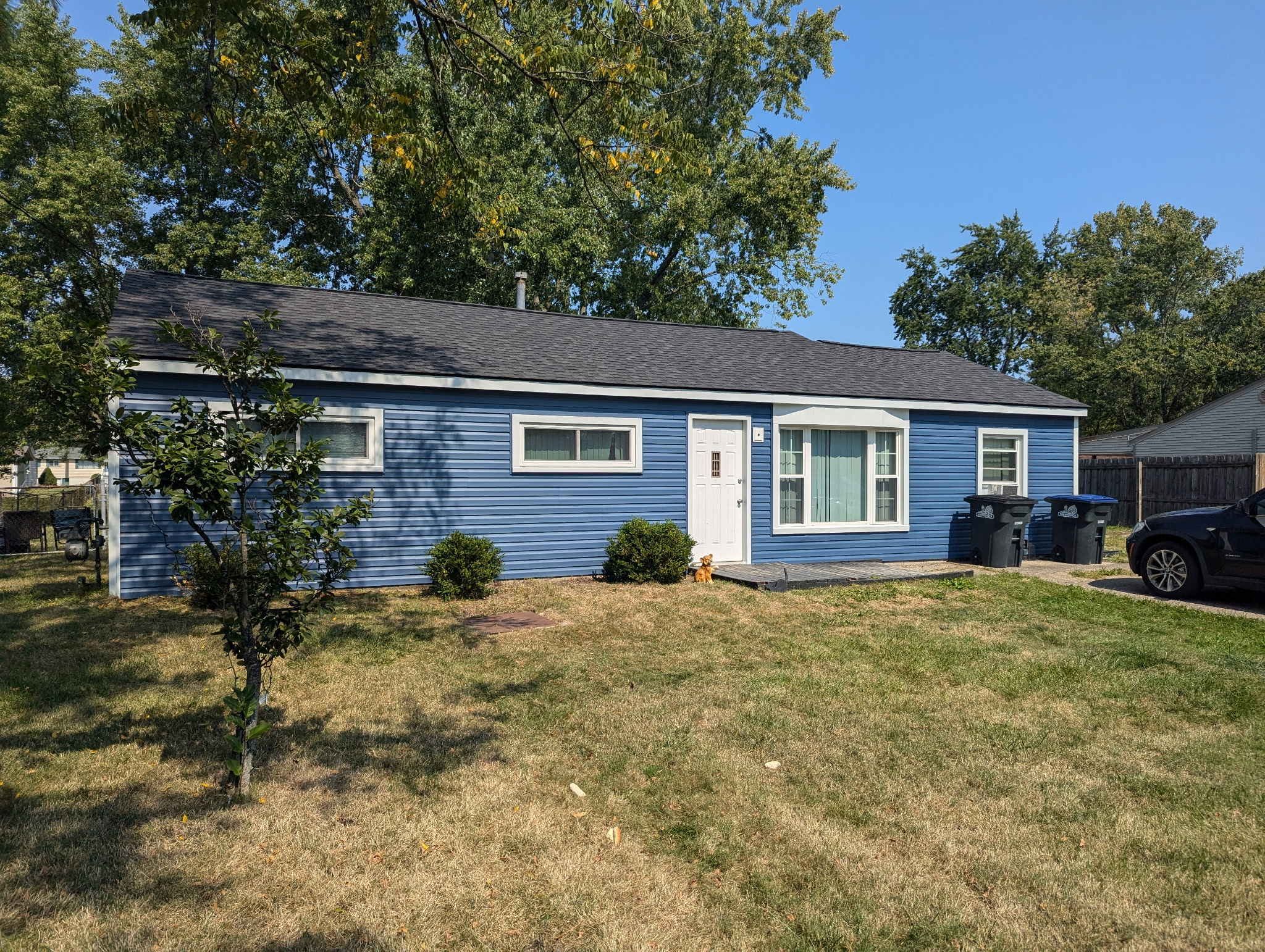New blue vinyl siding and charcoal roof replacement on a ranch home — Northeast Ohio