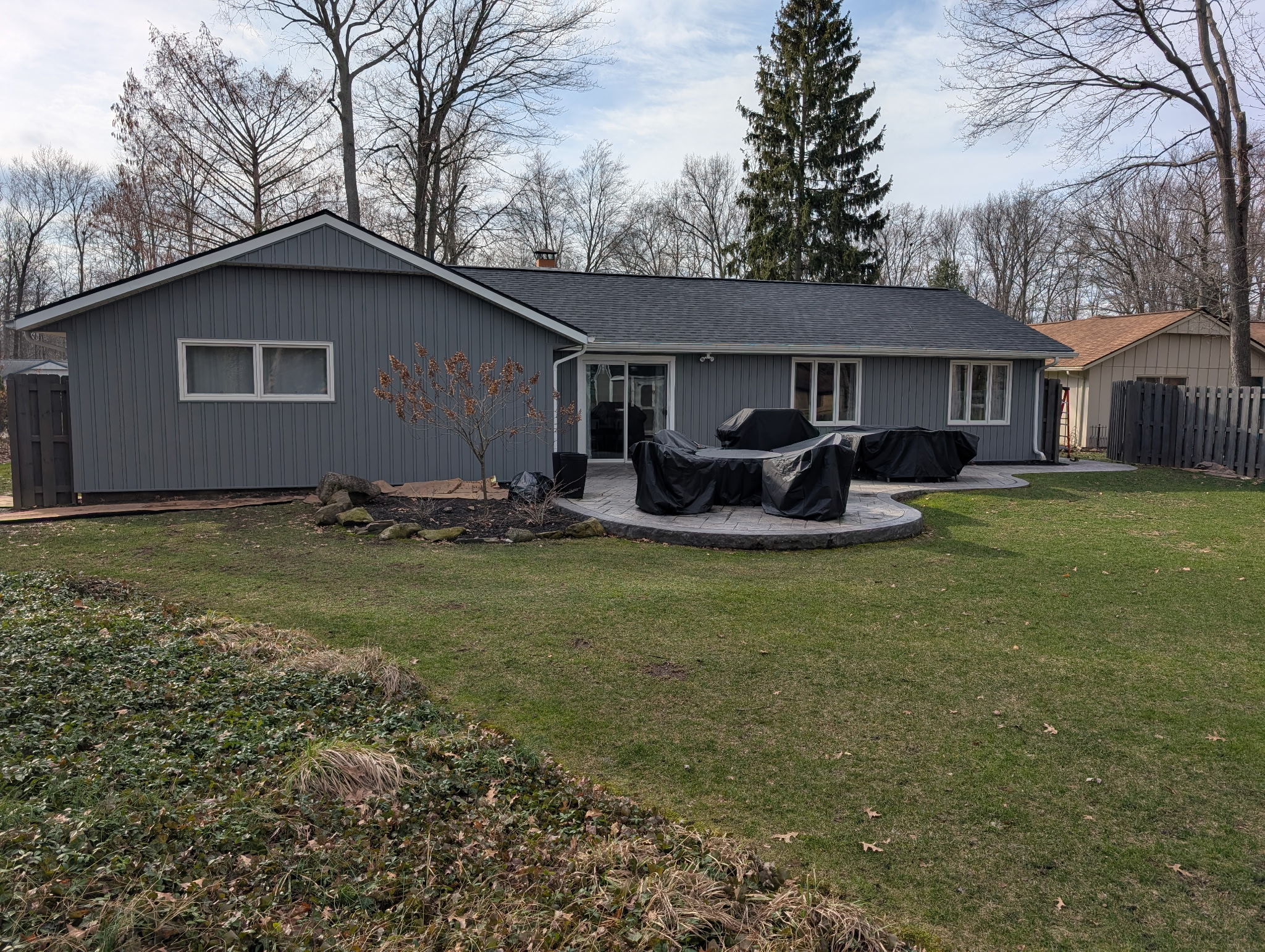 New gray board and batten siding and charcoal roof on a ranch home — Northeast Ohio