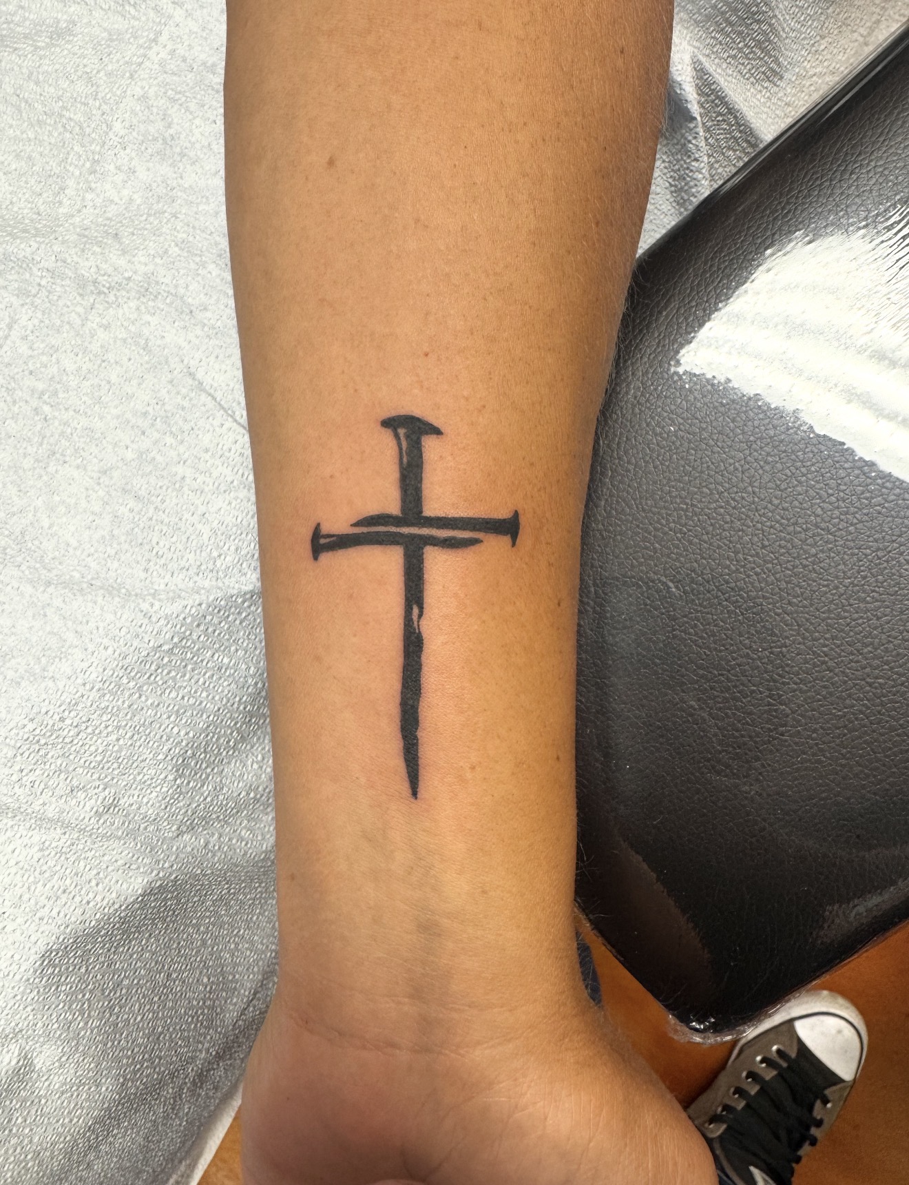 Nail cross tattoo by Marc Cabos.