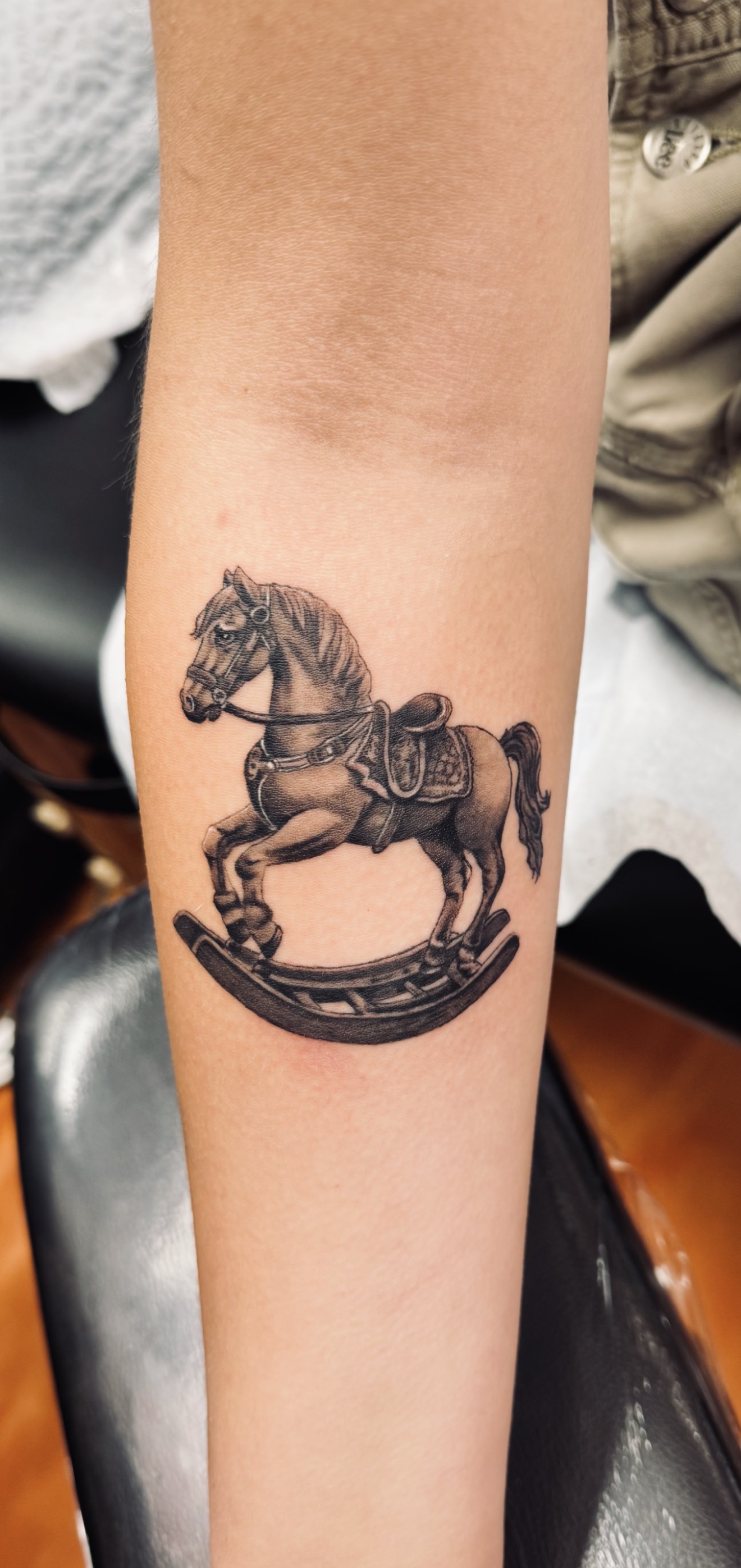 Marc Cabos fine-line rocking horse tattoo
