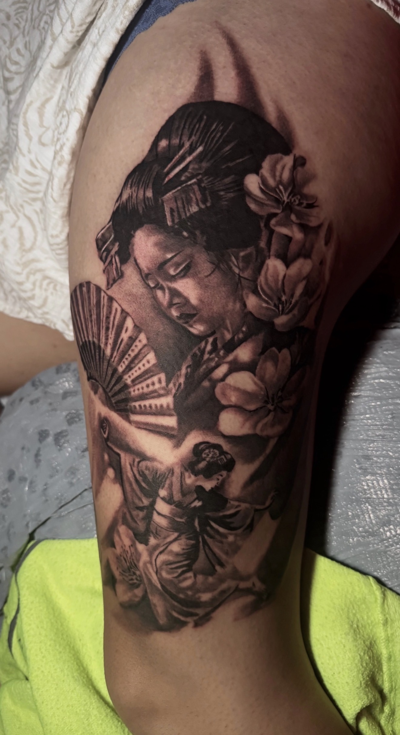 Black-and-grey geisha fan and flowers tattoo by Marc Cabos