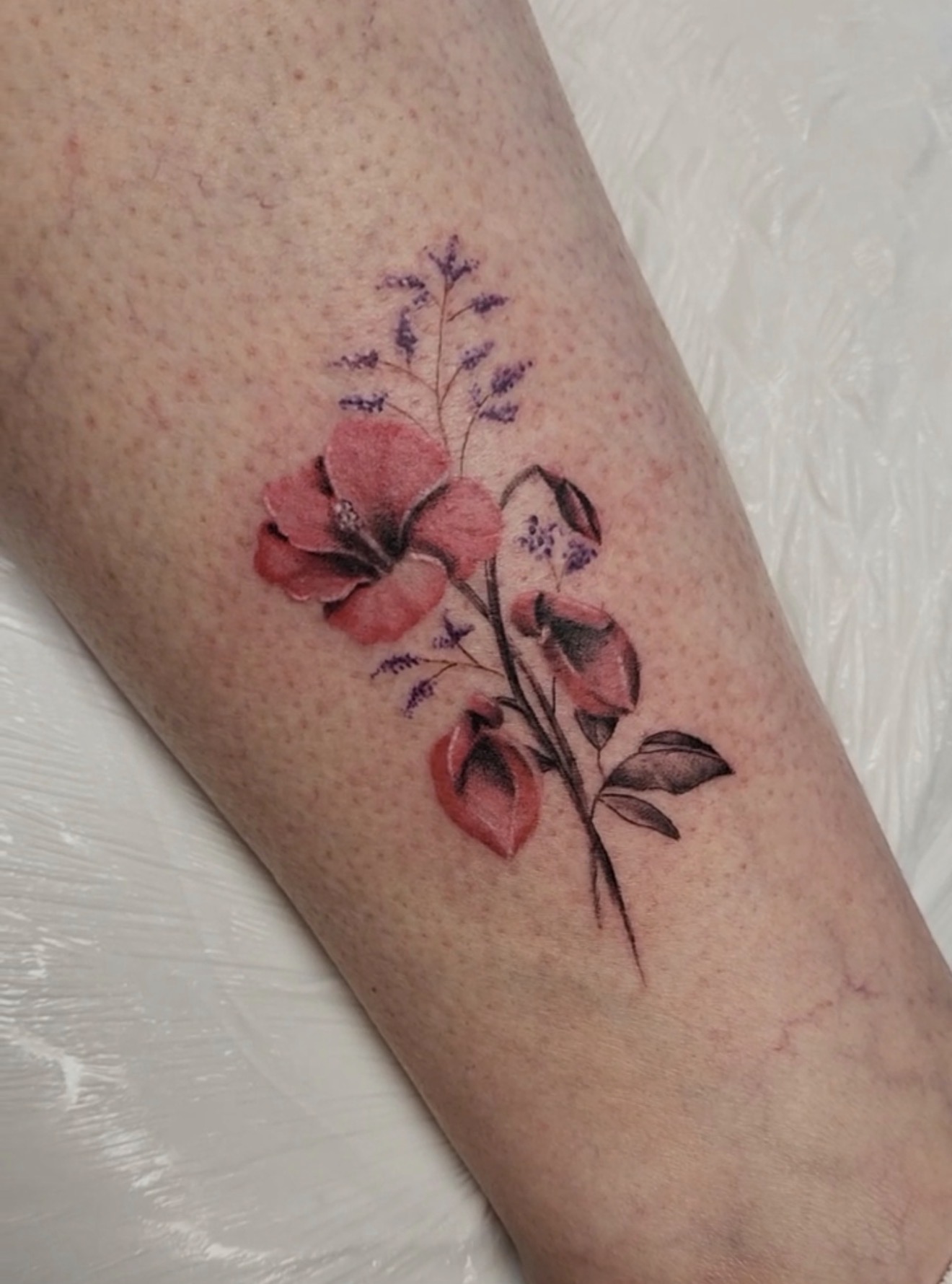 Small red floral tattoo by Marc Cabos