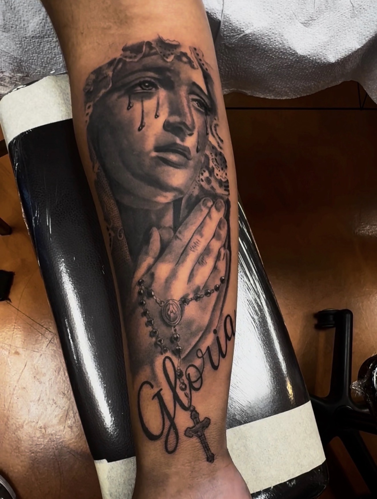 Black-and-grey praying Virgin Mary tattoo with rosary by Marc Cabos