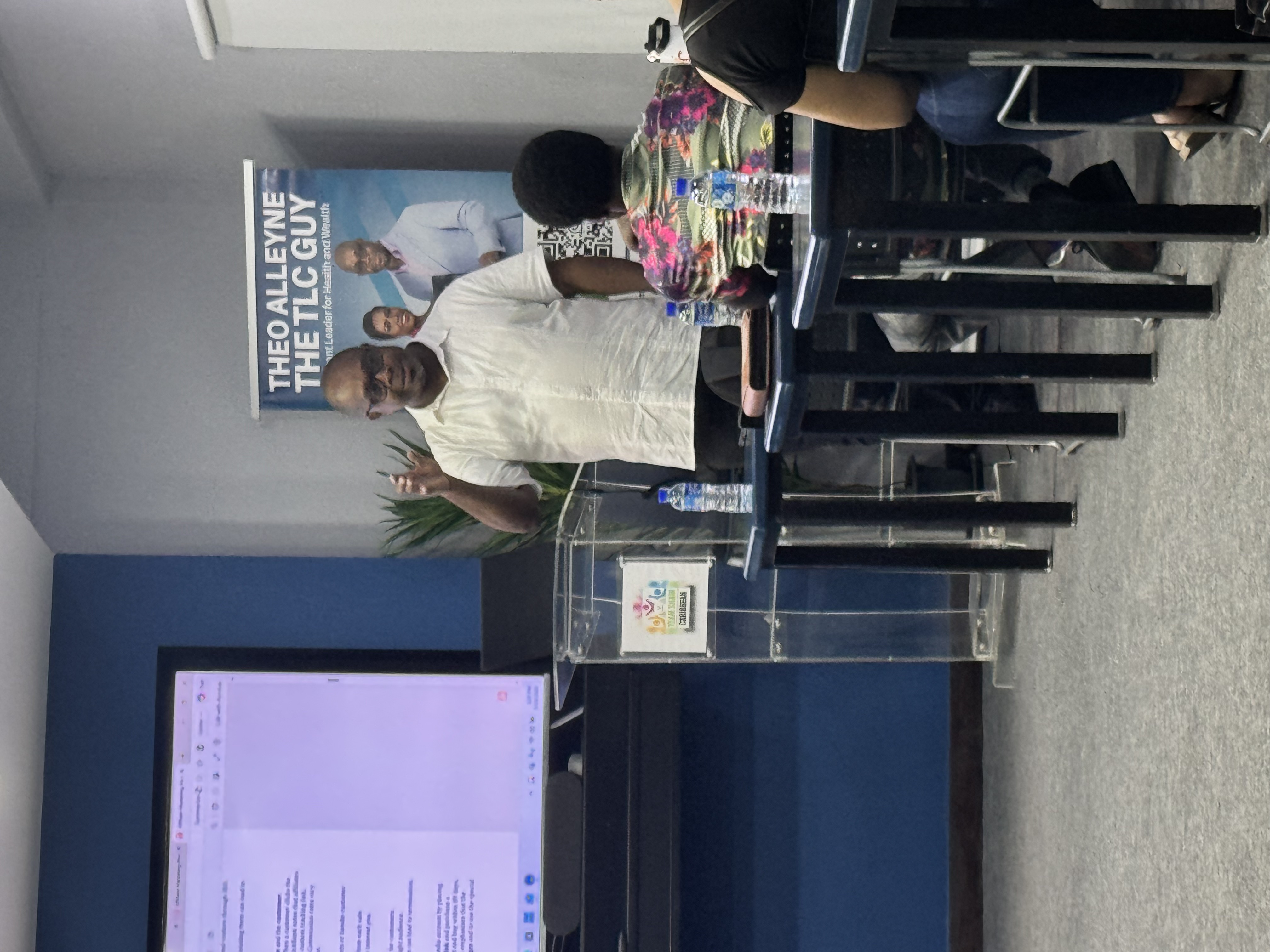 Coach Theo Alleyne teaching a business and wellness workshop to students in a classroom.