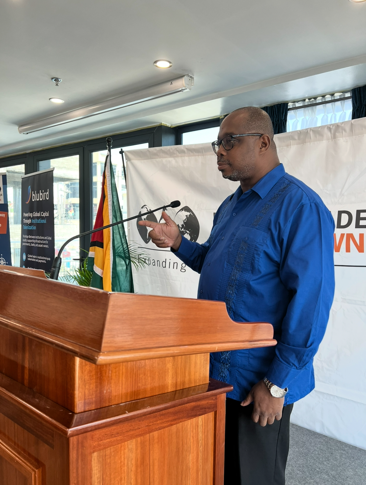 Coach Theo Alleyne speaking at a business and wellness event from a podium.