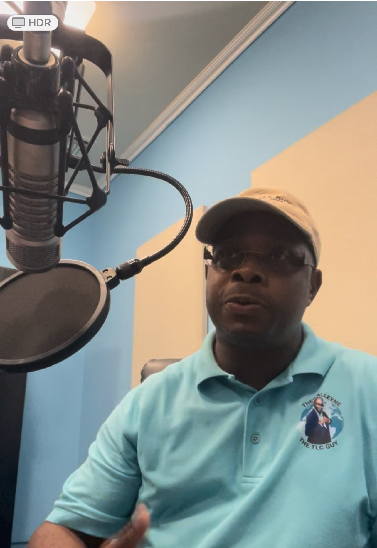 Coach Theo Alleyne speaking live on a wellness and business radio program with a studio microphone.