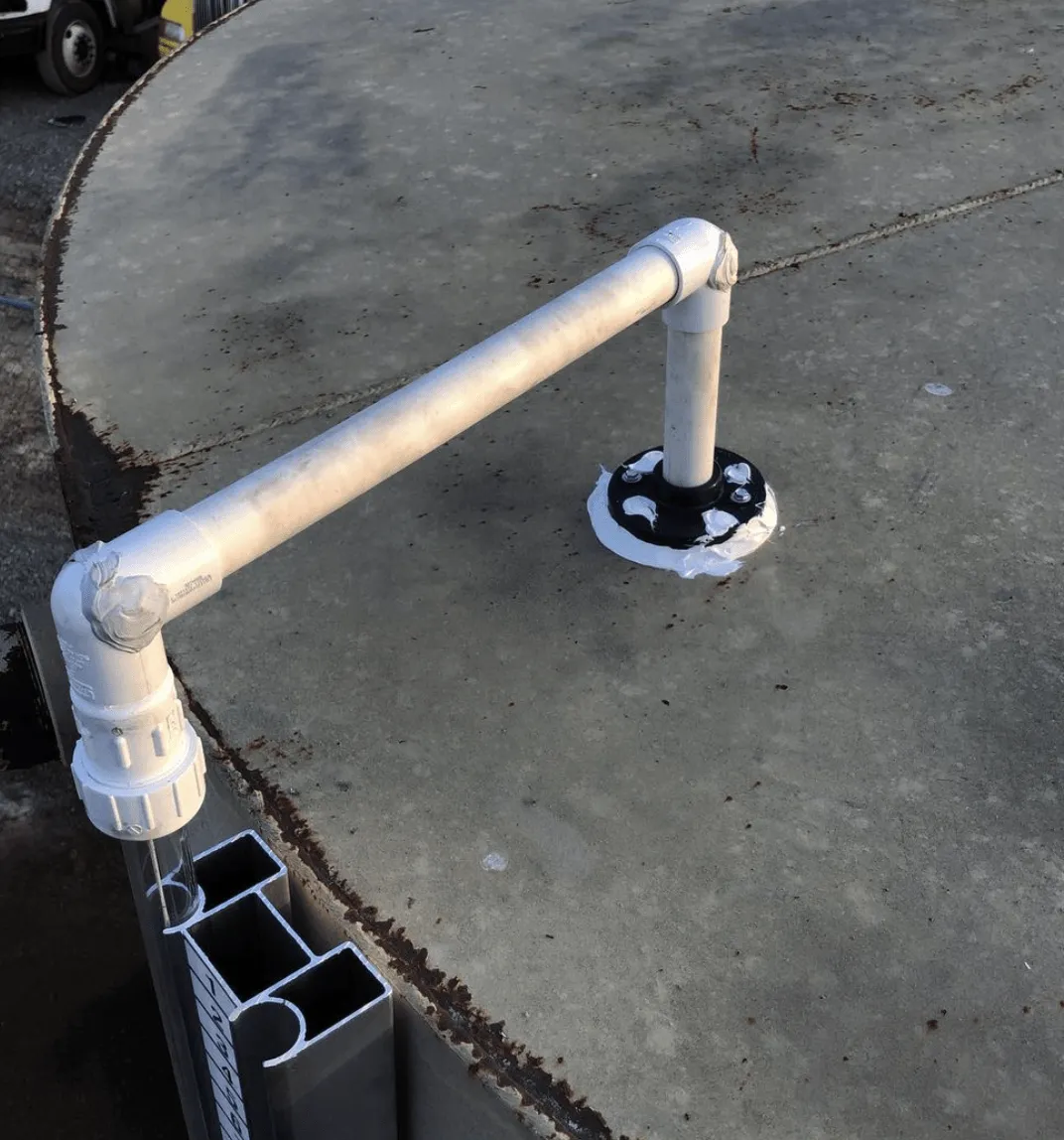 Close-up of Troglin patented external tank gauge tube mounted on oilfield storage tank