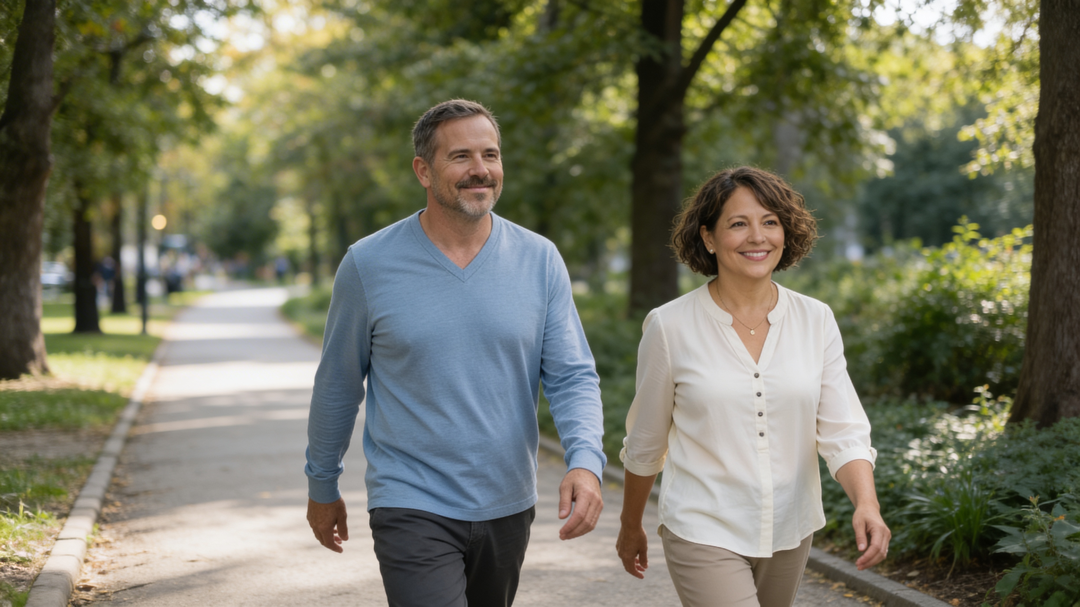 A couple walking confidently together on a sunny park path