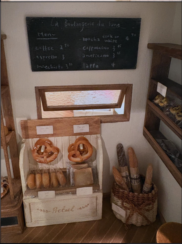 Detailed miniature bakery counter with a chalkboard menu, breads, and a basket