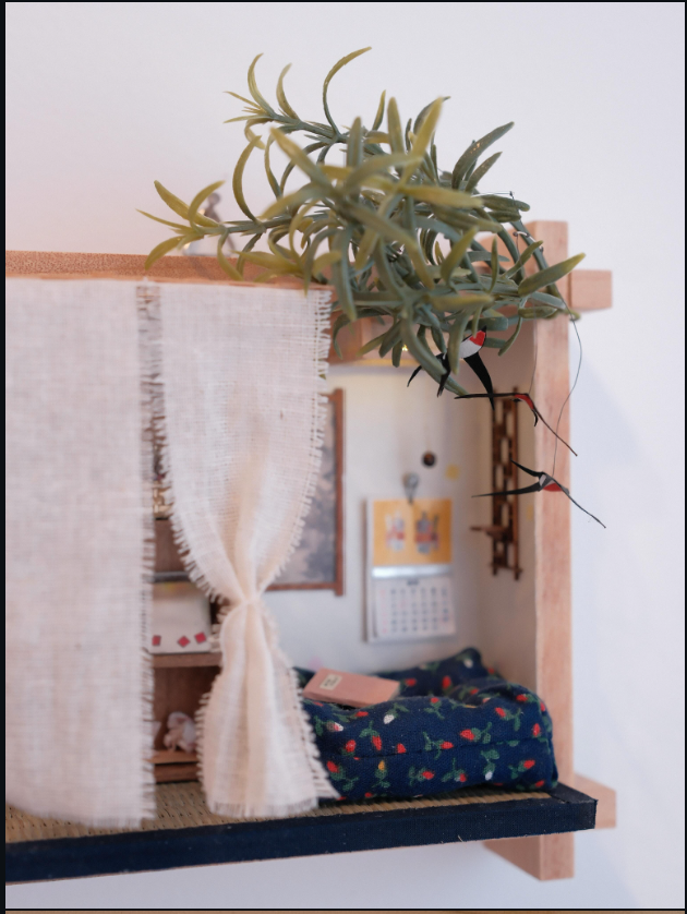 Quiet miniature room with a draped curtain, greenery, birds, and a floor cushion