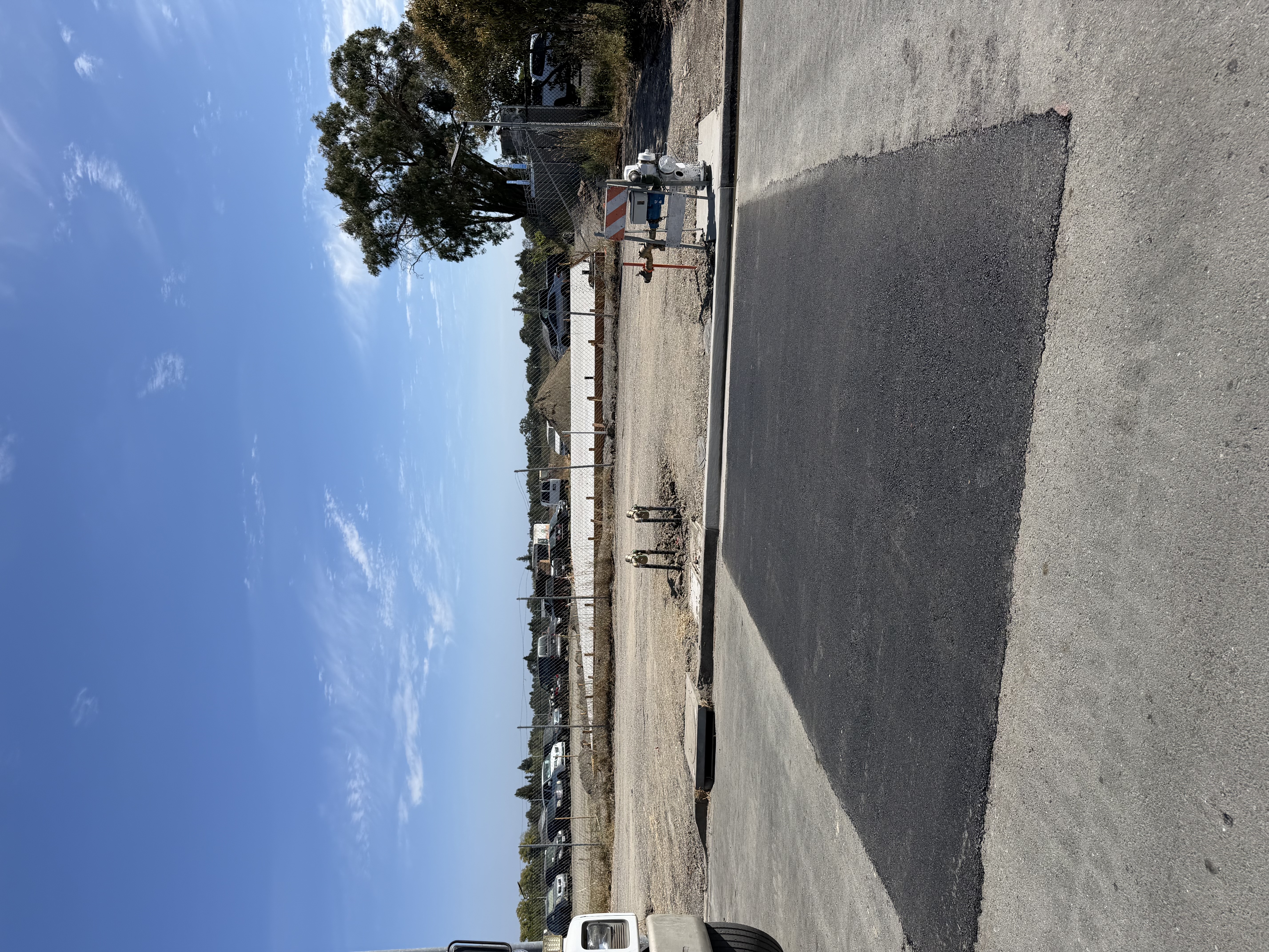 Fresh asphalt and utility work at a commercial site