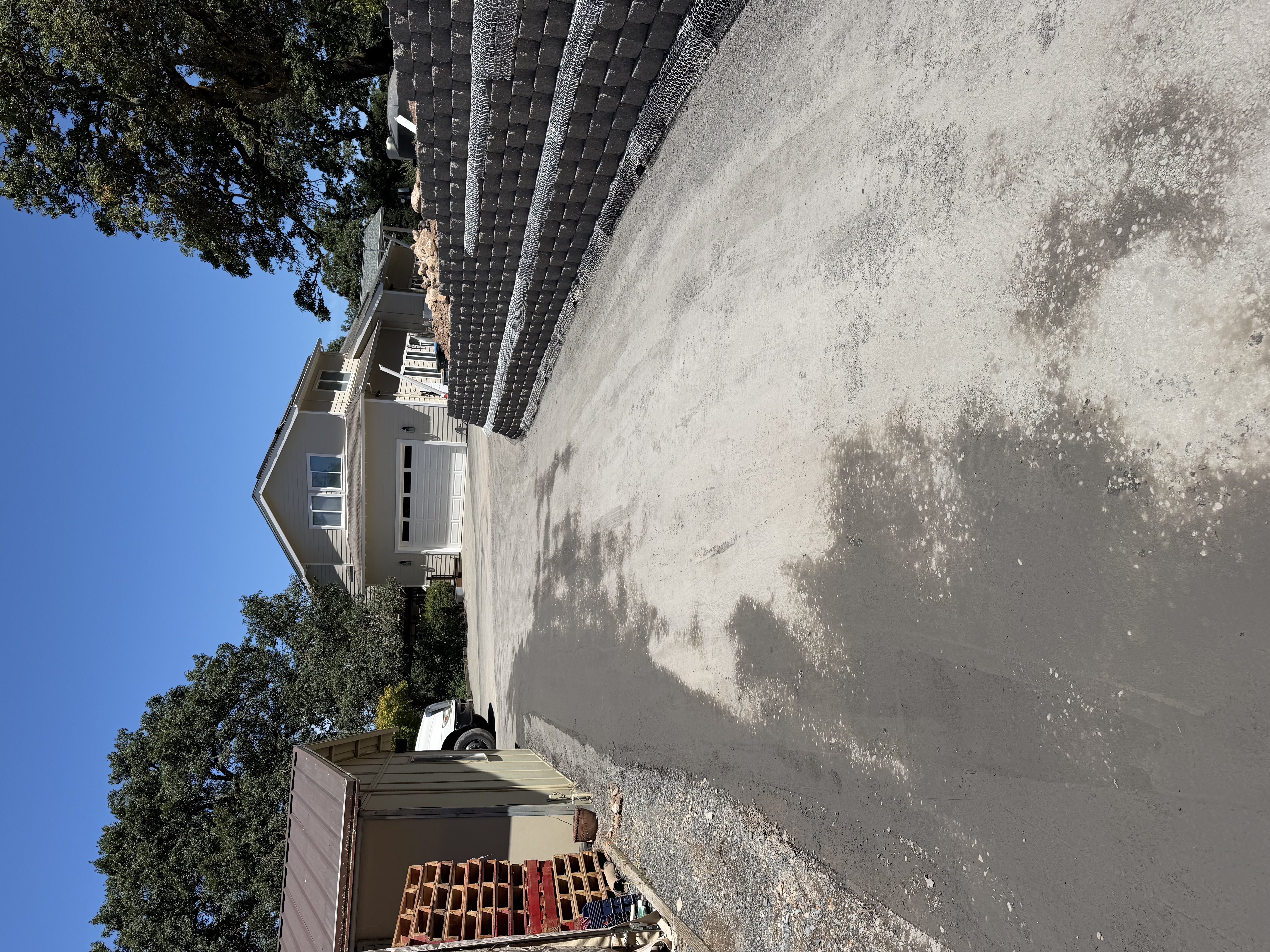 Paved residential driveway beside a block retaining wall