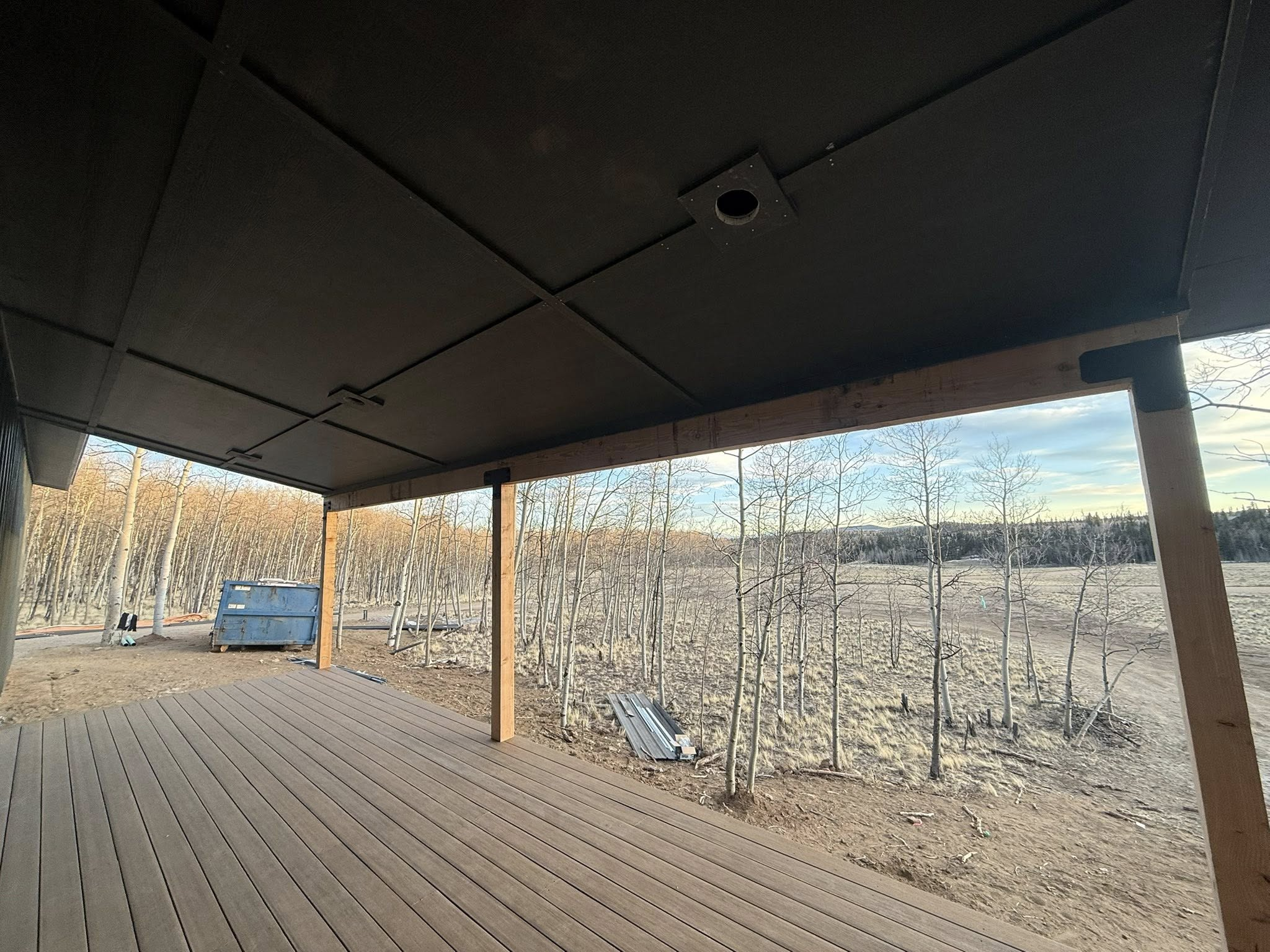 Large covered deck with timber posts overlooking mountain aspen forest