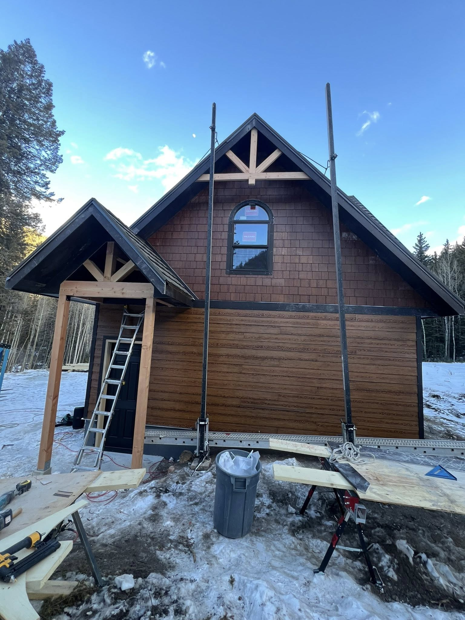 Cabin siding and framing construction in winter with wood shingle exterior
