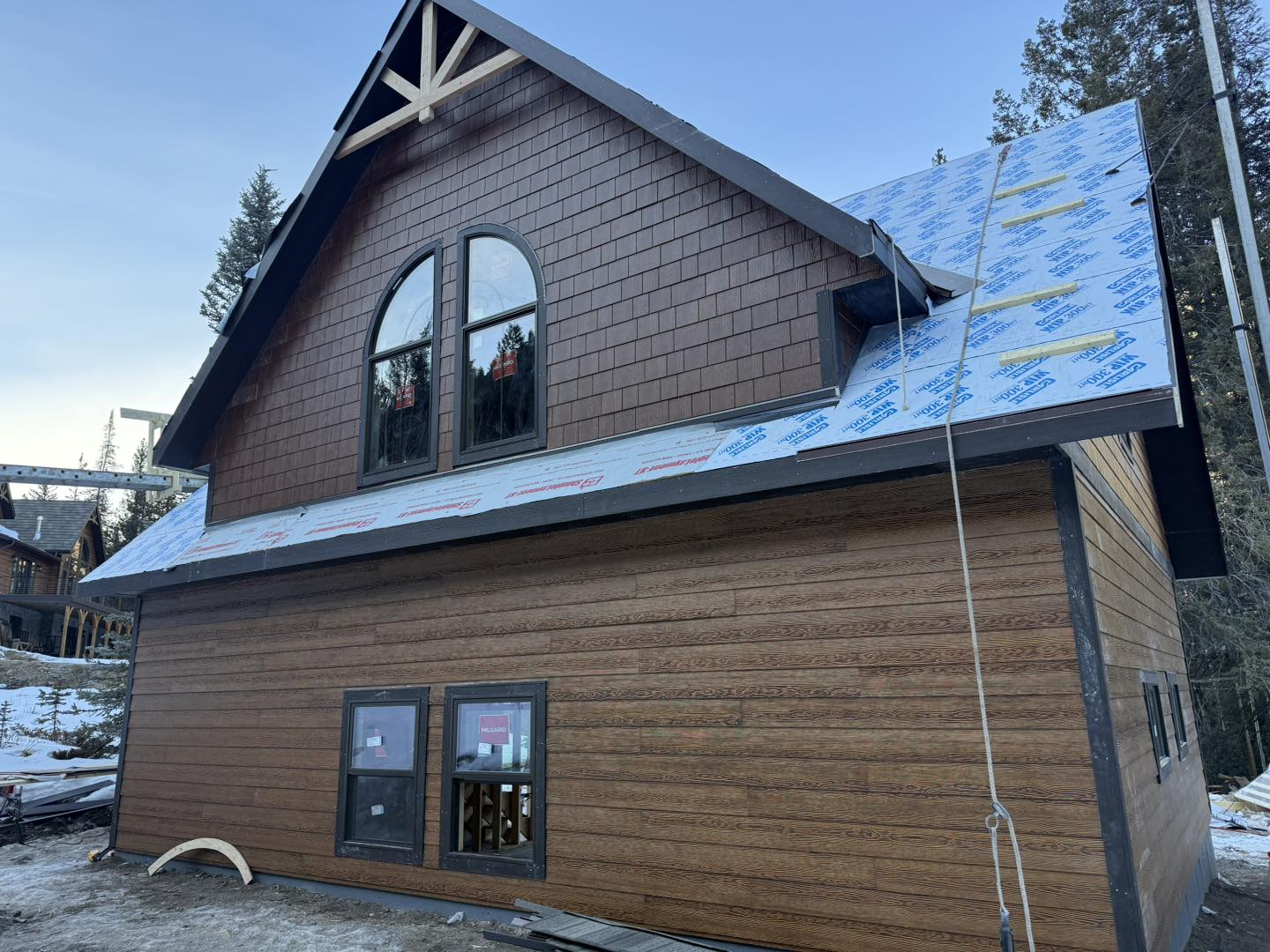Two-story cabin exterior siding and roofing in progress