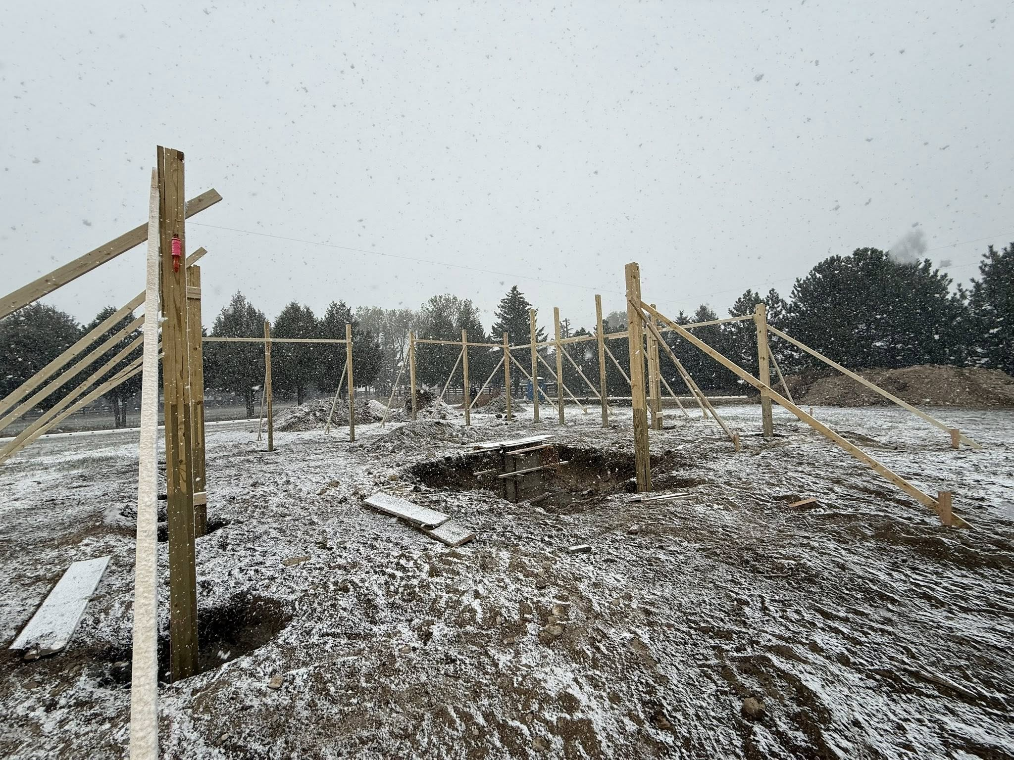 Barn post layout in snow with foundation excavation and bracing