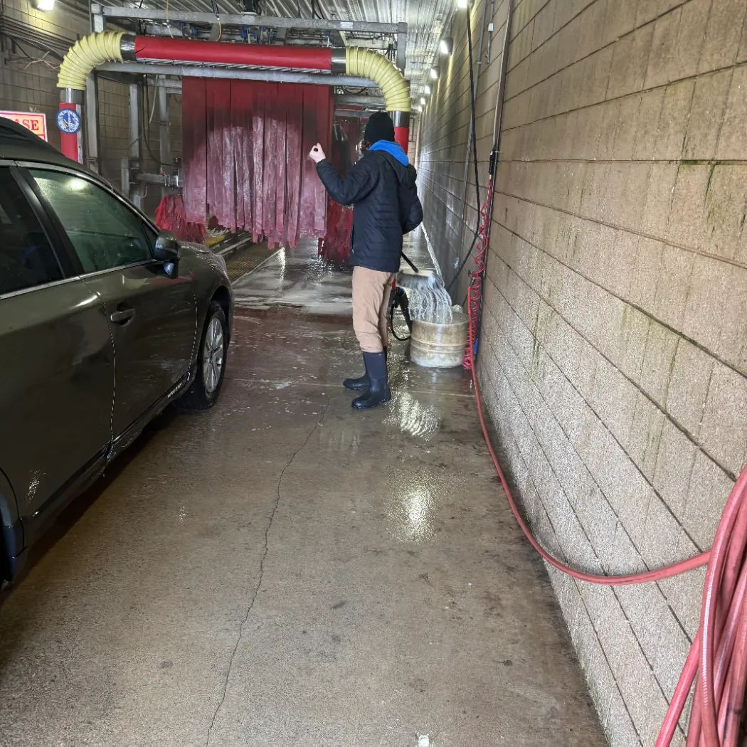 Staff member guiding a vehicle into the automatic wash tunnel