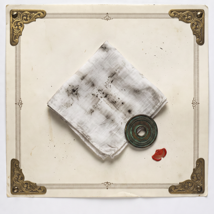 Numbered archive print showing a soot-marked handkerchief, one of six monthly keepsakes and not evidence