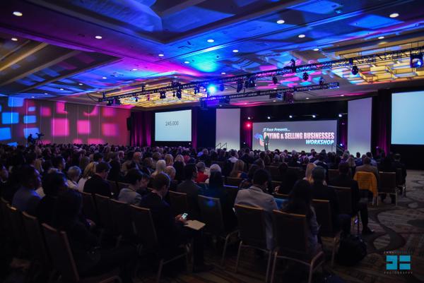 Audience watching a live business workshop in a lit conference hall