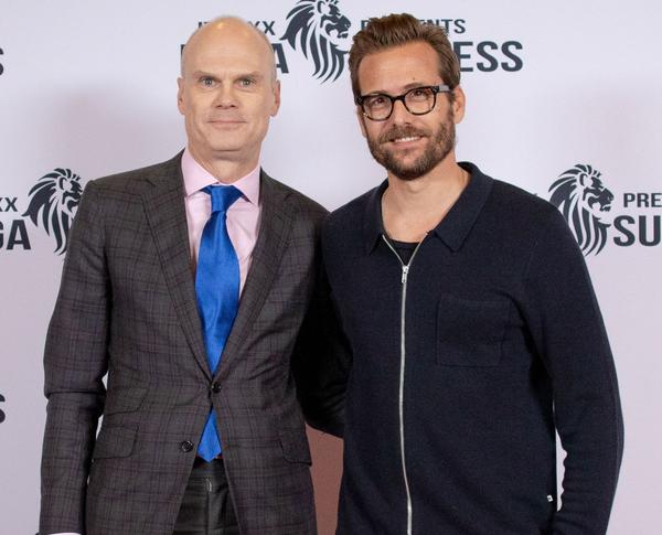 Two men smiling together at a formal event