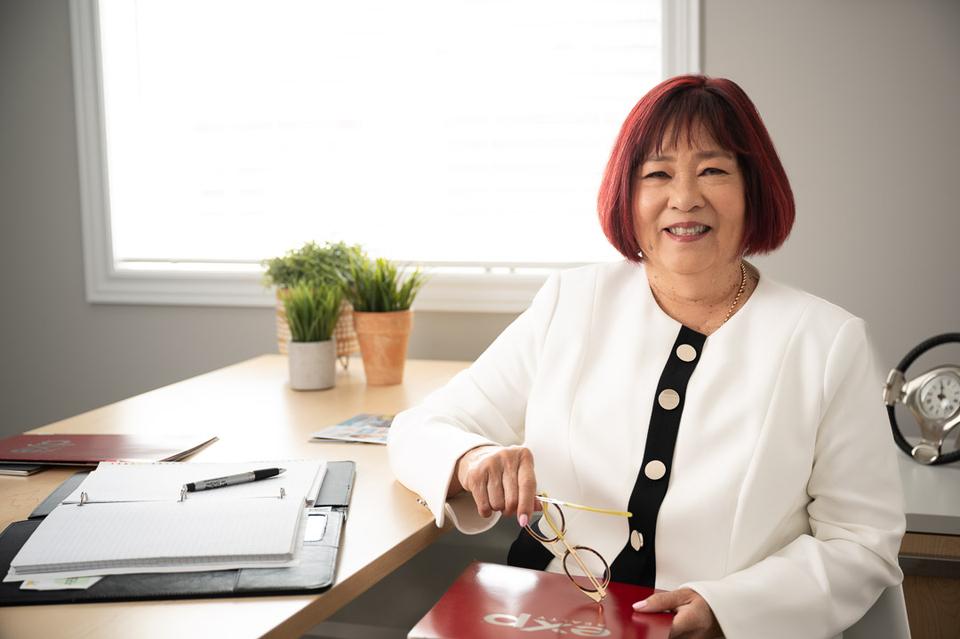 Joan Hing King seated at her desk