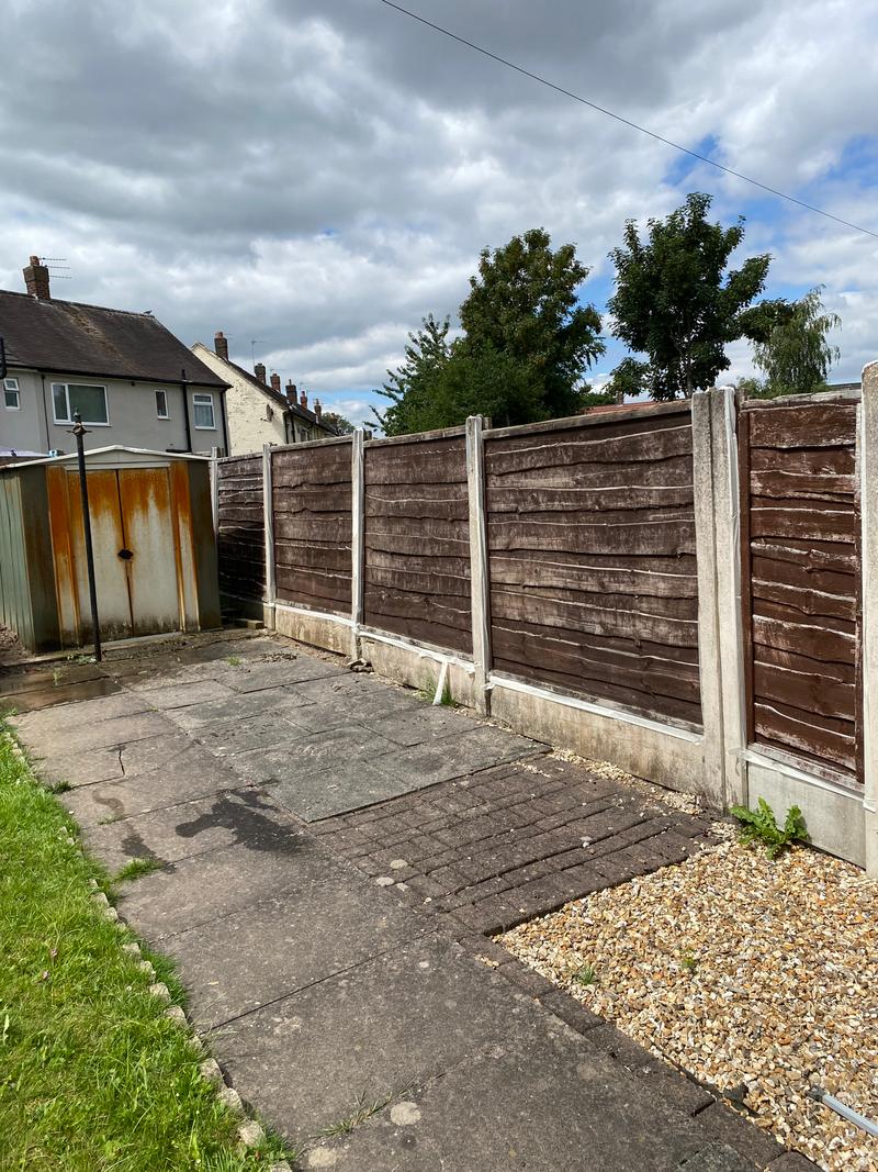 Before photo of a weathered timber fence in an outdoor area