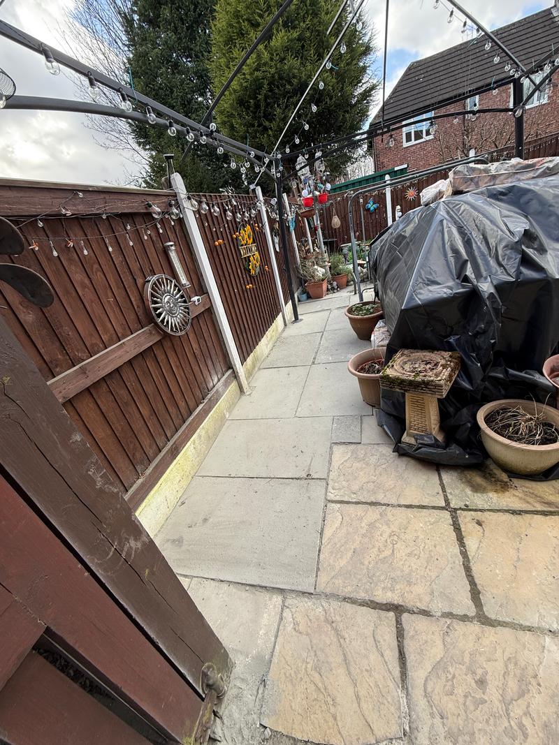 After photo of the same side passage with new paving and flagging beside a fence