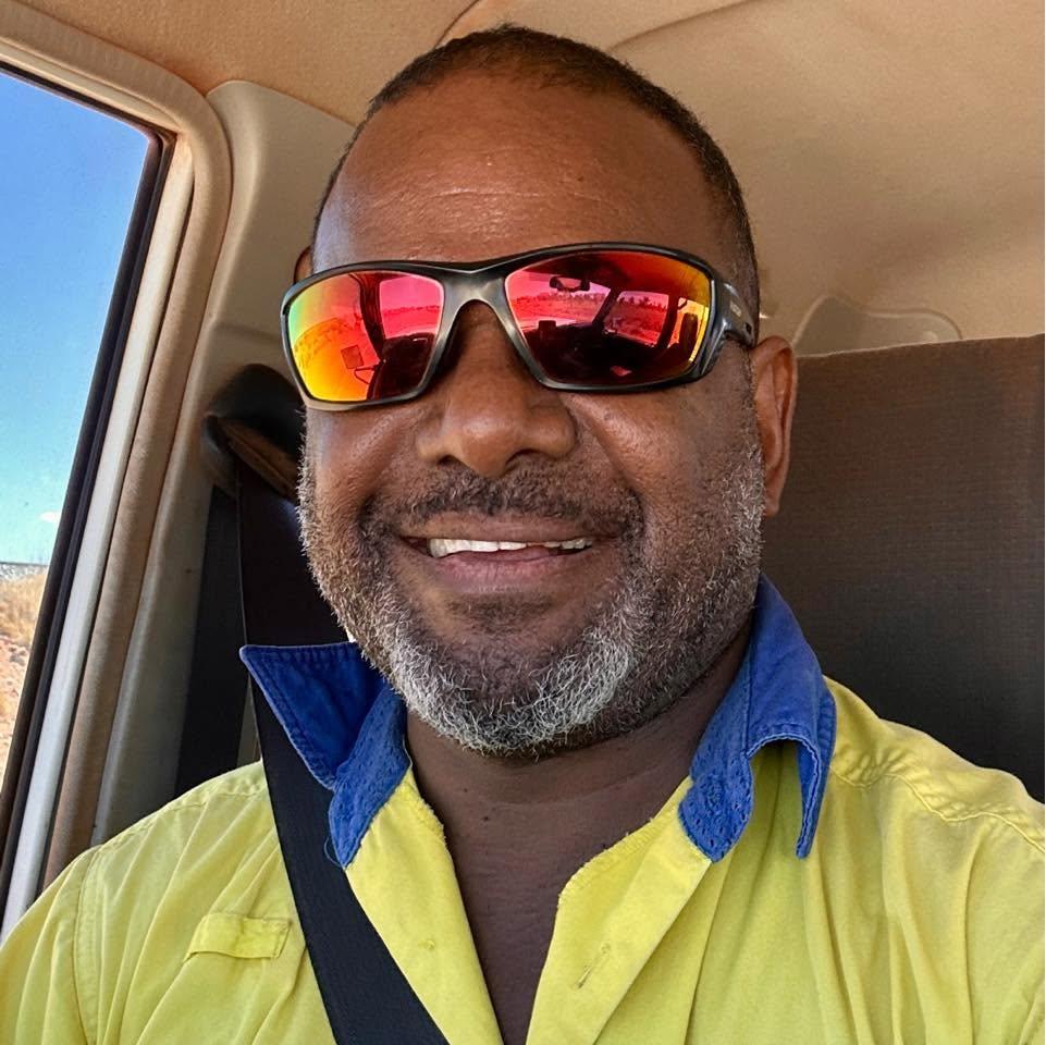 Portrait of MISERON LEVI, wearing sunglasses and smiling.