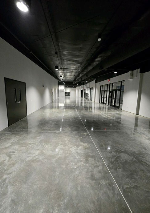 High-gloss facility corridor with expansive polished concrete floor under recessed lighting