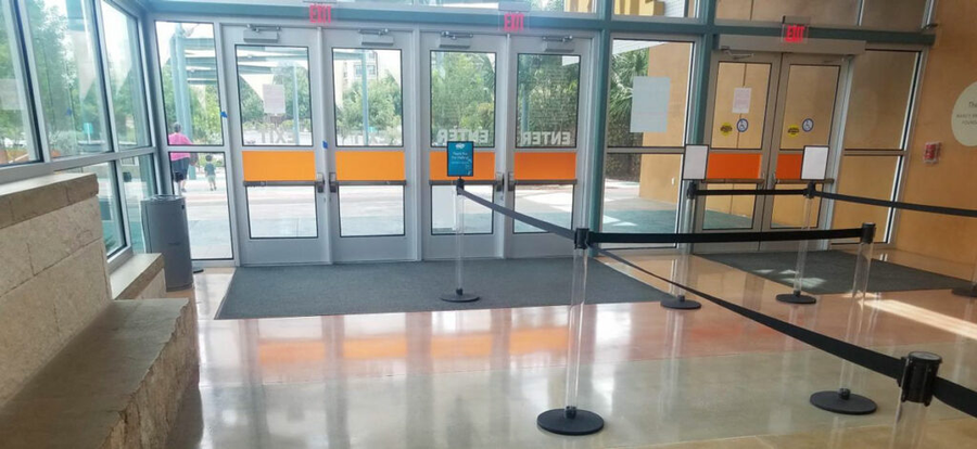 Protected entrance flooring showing reflective clear coat near glass doors at sunset