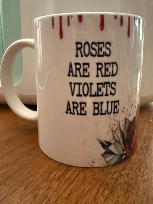 Front view of a white 12oz mug with red dripping accents, quote lettering, and a rose design