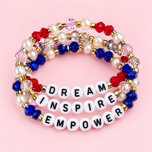 Colorful red, blue, pink, clear, pearl, and gold-accented beaded bracelets on a pink background