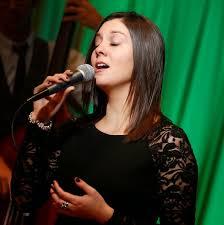 Vocalist singing into a microphone on stage