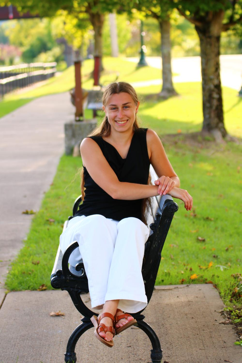 Timeless Events coordinator smiling while seated on a park bench outdoors