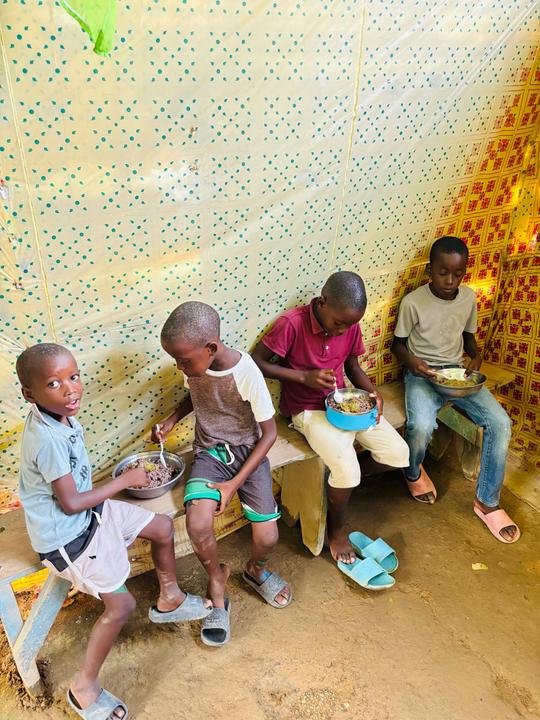 Children eat prepared meals during nutrition support in Haiti