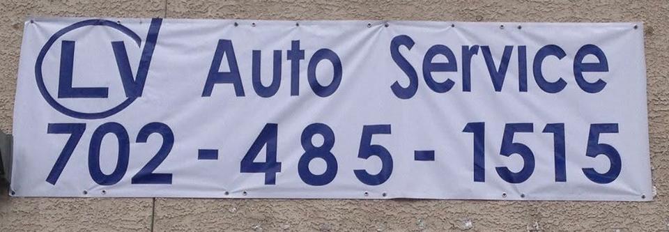 Wide white auto-service banner with blue lettering mounted on a wall.
