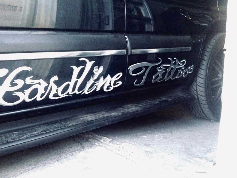 White decorative lettering across the door of a dark vehicle.