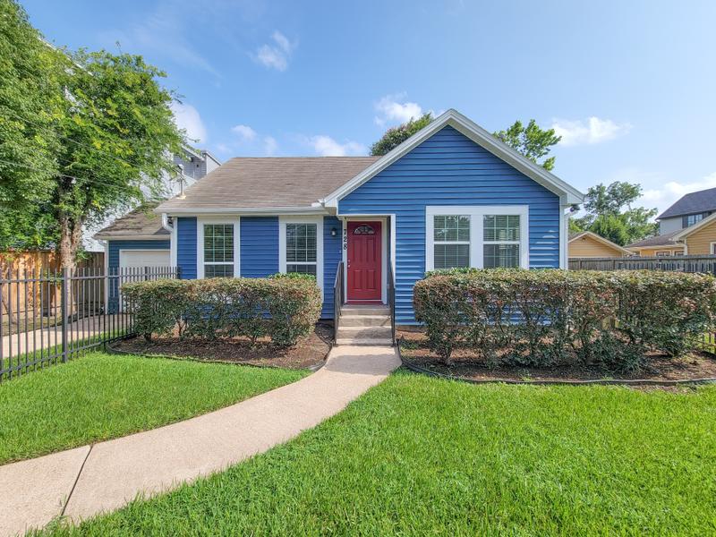 Blue house exterior with a red front door and front lawn.