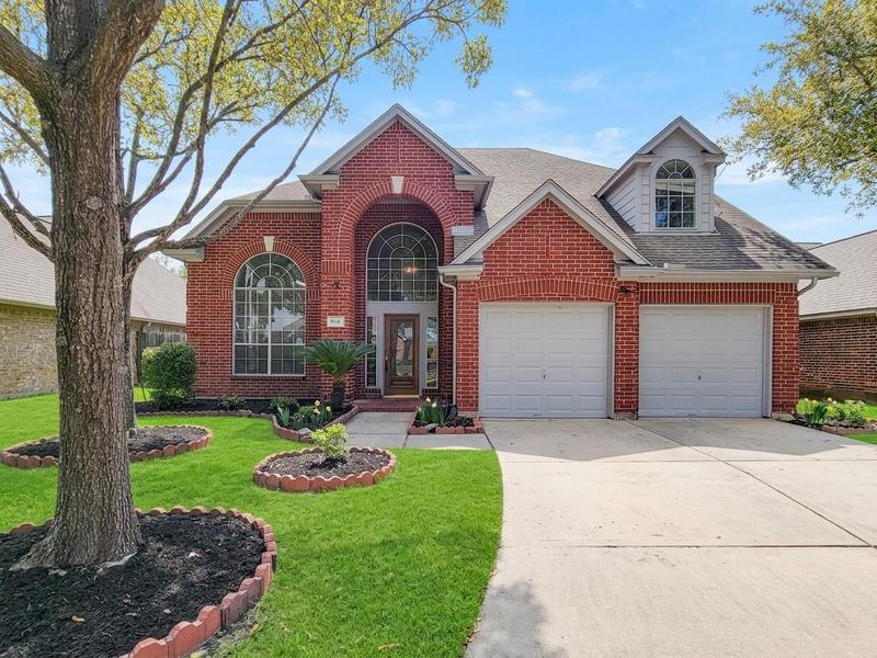 Two-story brick home with a front lawn and double garage.