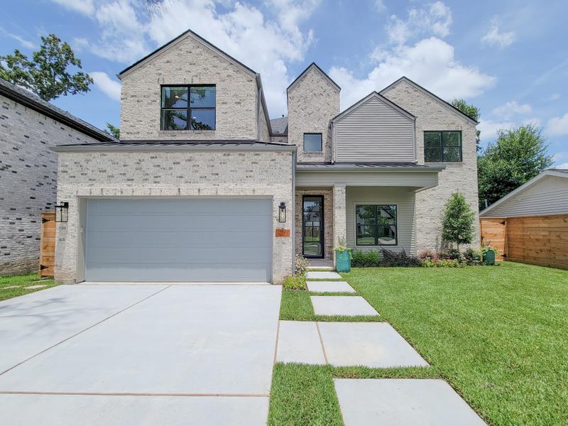 Modern two-story light-stone home and front lawn.