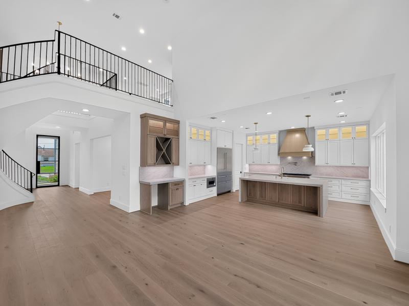 Bright open kitchen with a long island and staircase.