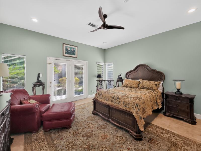 Bedroom with a carved wood bed, matching furnishings, and sitting chair.