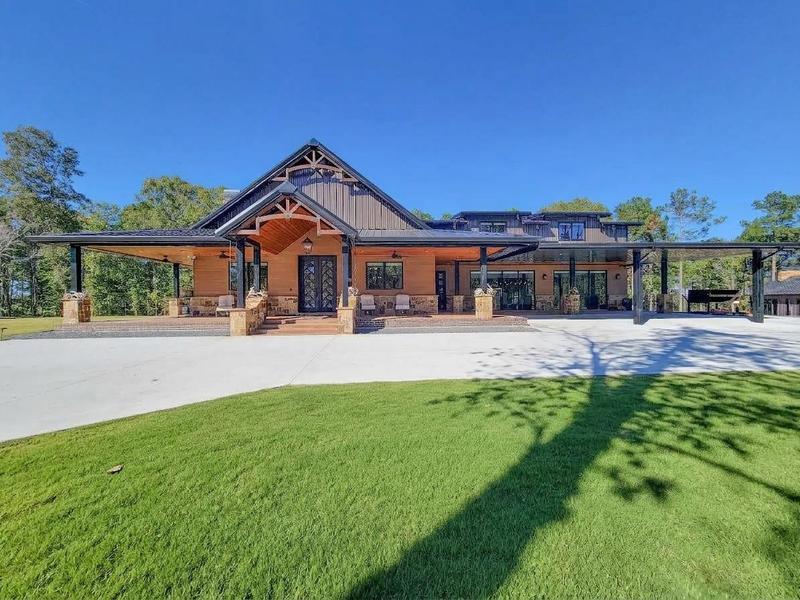 Wide home exterior with a covered patio and front lawn.