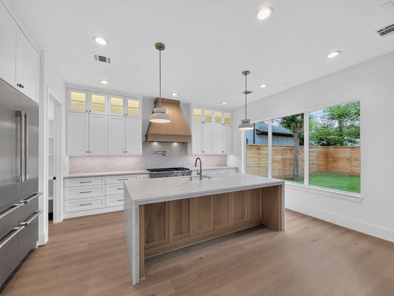 Bright kitchen with a wood-front island and wide windows.