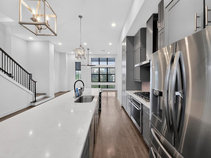 Modern kitchen with a long island and stainless steel appliances.