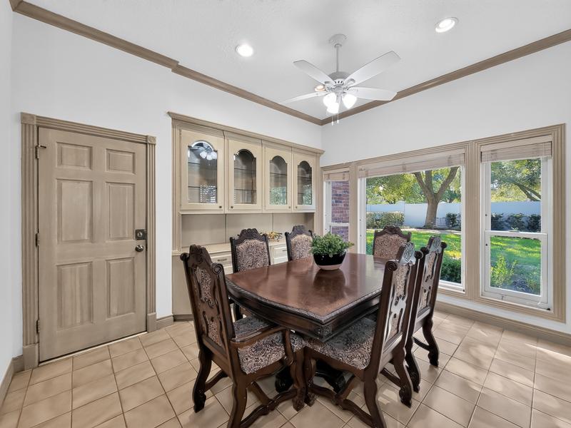 Dining room with a dark wood table and large windows.